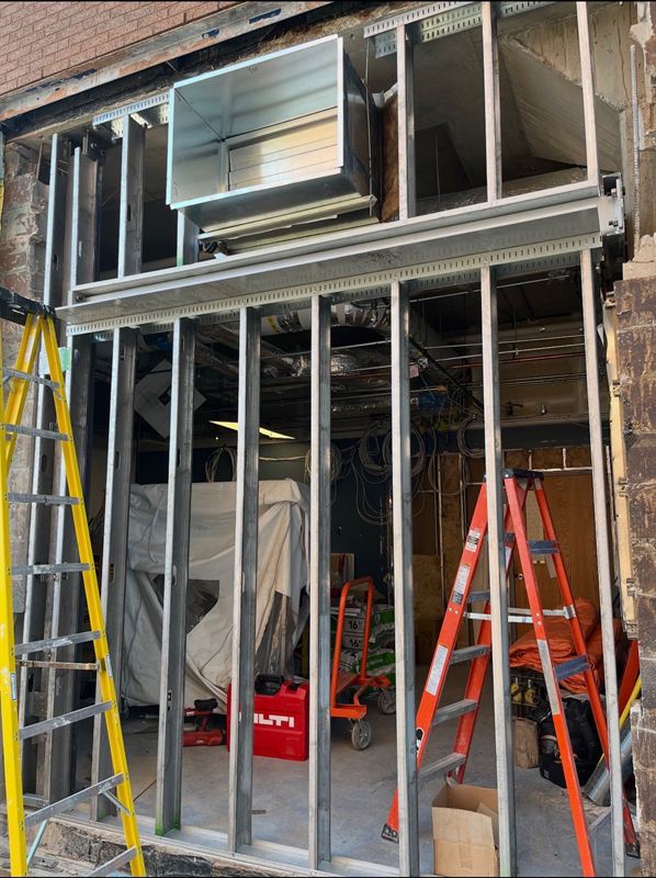 Exterior masonry opening framed for a new storefront and louvre