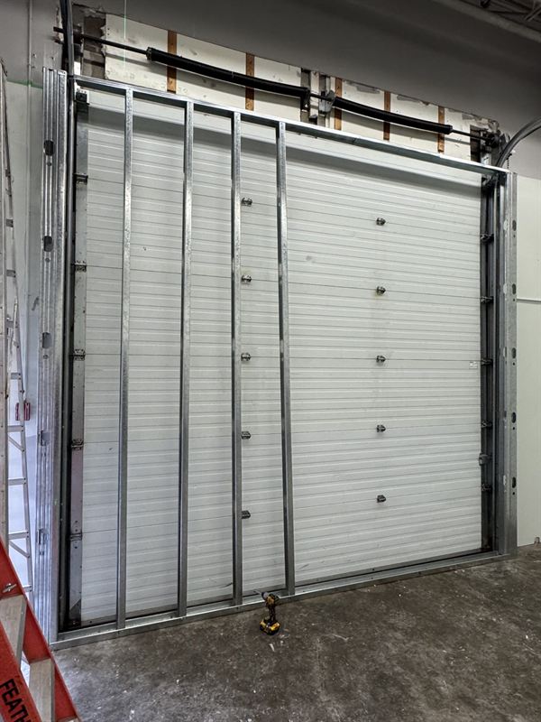 Overhead door opening infilled with steel stud framing