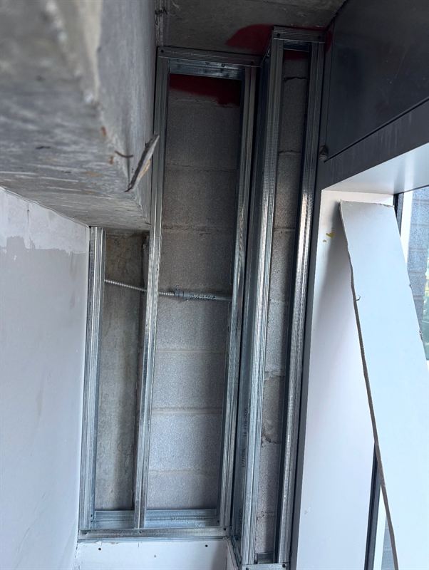 Steel stud soffit detail framed against concrete structure