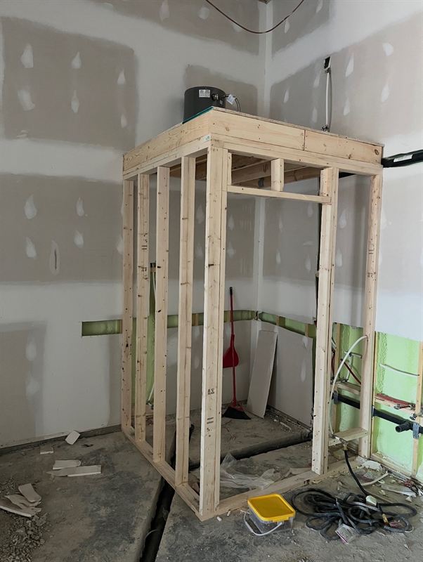 Framed utility enclosure with water heater platform